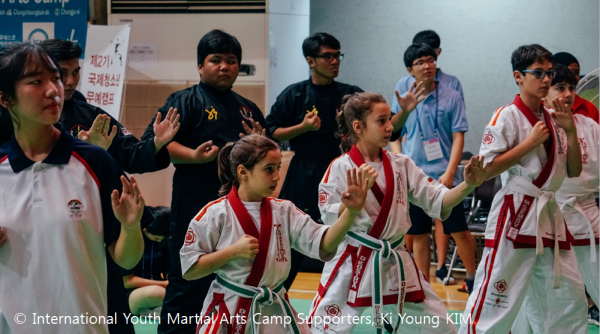 Youth in martial arts postures at the IYMAC